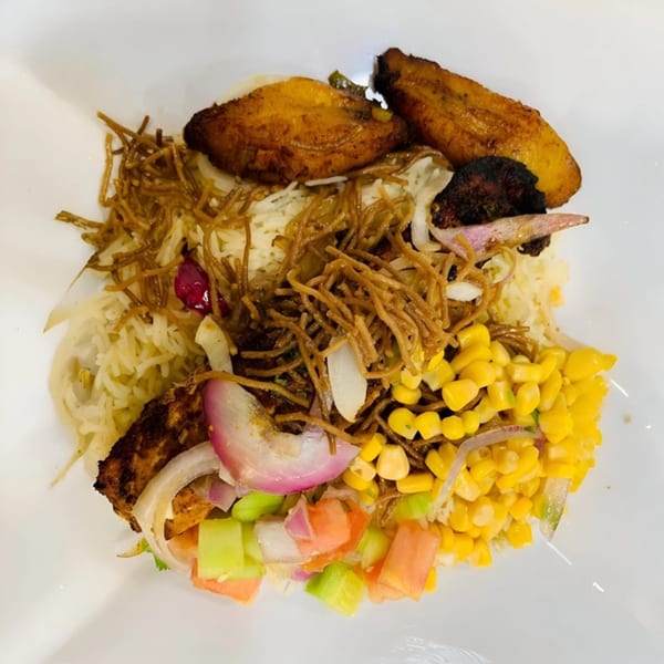 Afra Grill's African dish with rice, noodles, plantains, corn, and a fresh vegetable salad.