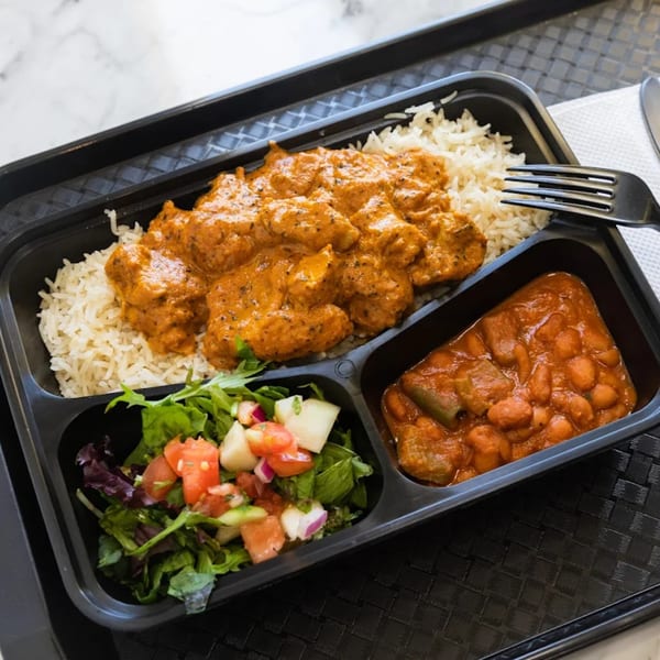 Afra Grill's African meal with rice, chicken in sauce, beans, and a side salad.